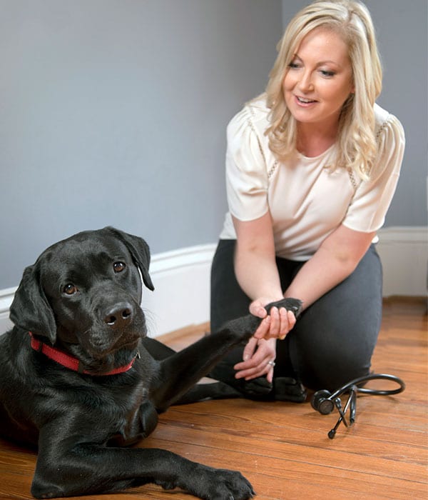 Vet holding dog's paw: Veterinary Consultations in Houston